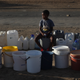 A boy keeps a spot in a queue for free water being transported in by the municipality, in Senekal, South Africa. Image: AP